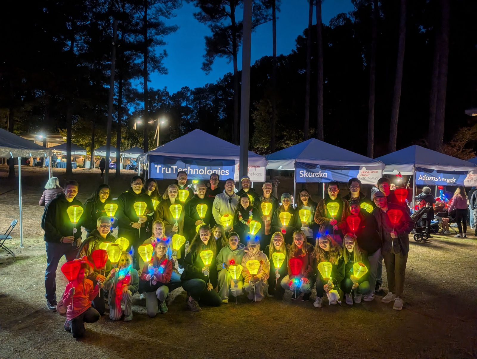 TruTechnologies team holding glowing lanterns at Light The Night 2025