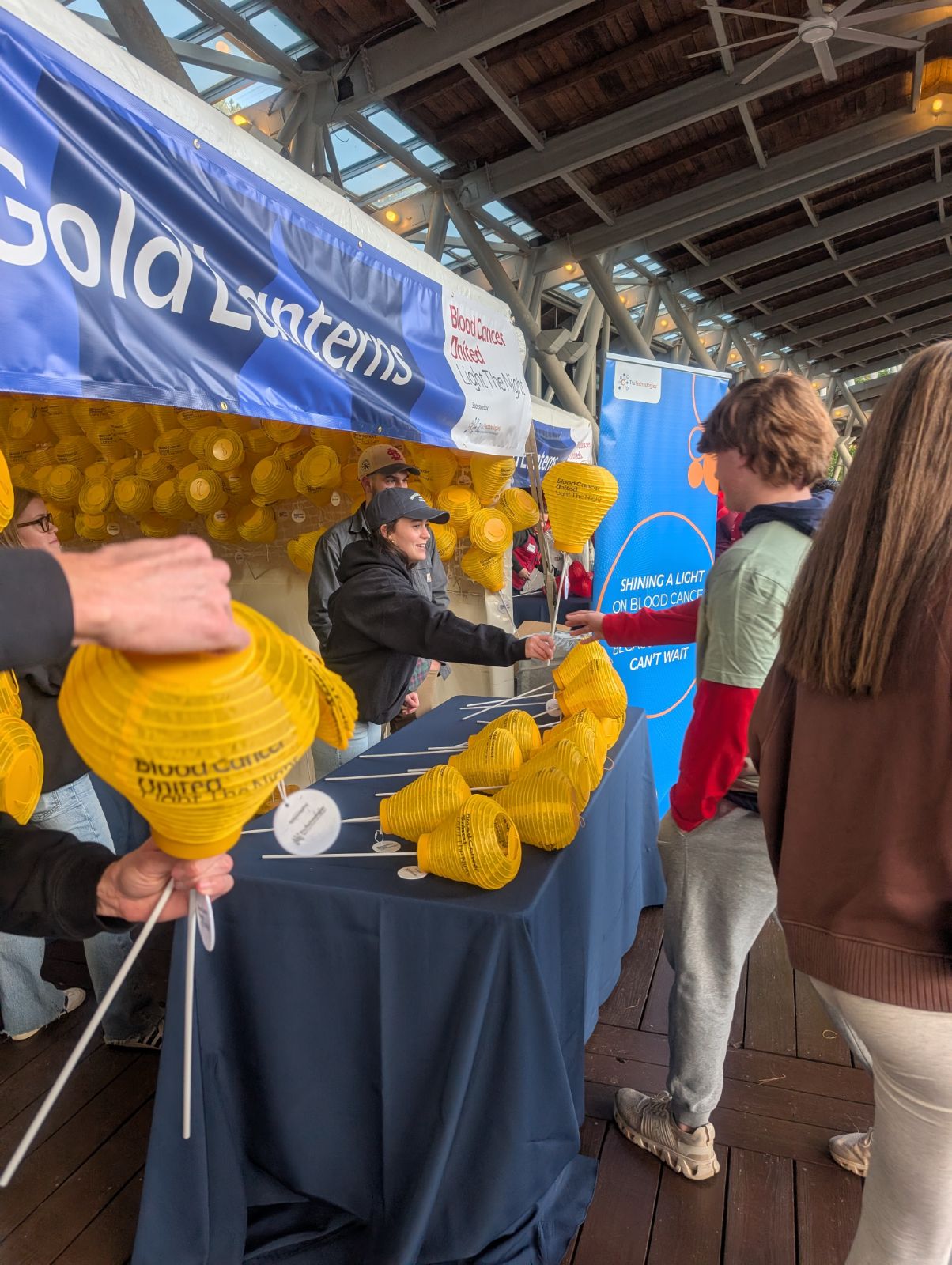 Team member handing out gold lanterns to attendees