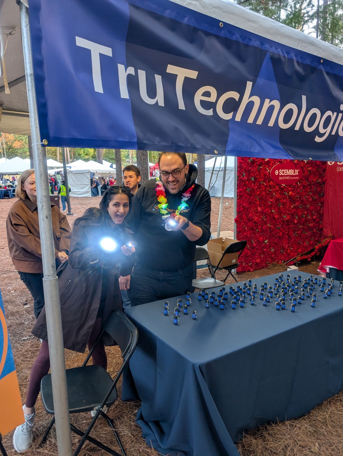 TruTechnologies team members with flashlights at the booth